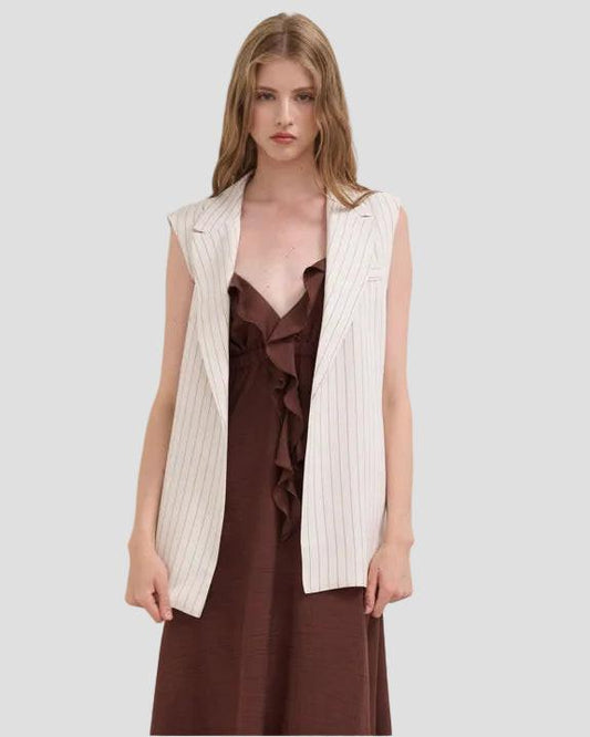 Gilet donna gessato color burro senza maniche su abito marrone, moda elegante.