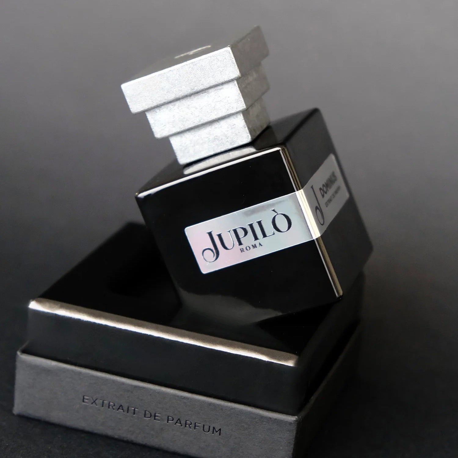 Flacone di profumo Jupilò Roma Dominus nero con tappo argentato, su sfondo nero elegante