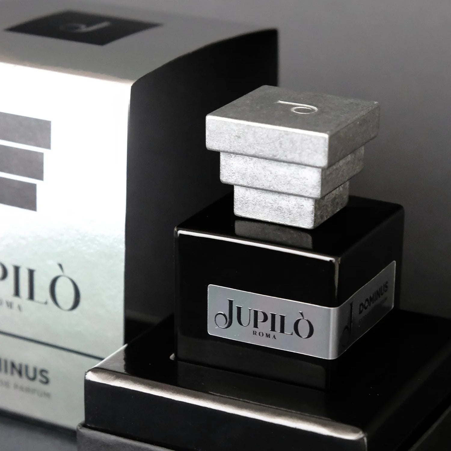 Flacone di profumo Jupilò Roma Dominus, design elegante nero con tappo geometrico argento.