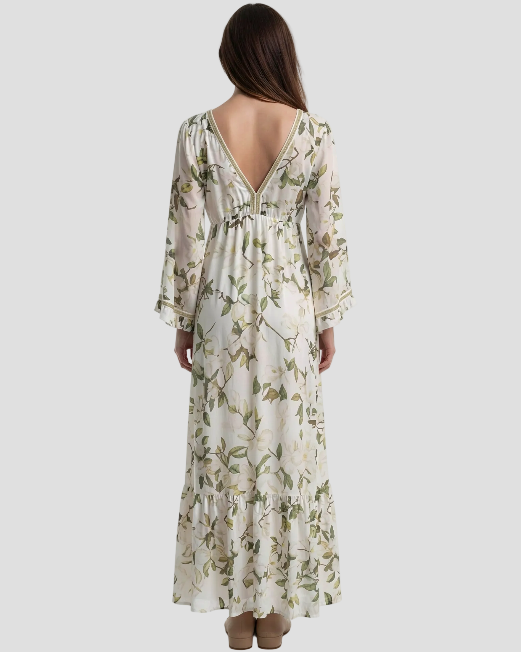 Modella di spalle indossa Abito lungo Pho Firenze in cotone e seta, fantasia floreale verde e bianca con nappine e taglio sottoseno.