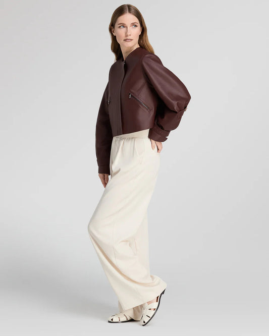 Giacca corta donna in pelle, pantaloni larghi crema, stile elegante moderno