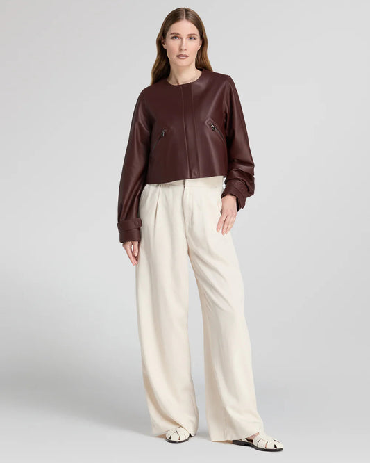 Giacca crop in pelle marrone con zip, pantaloni bianchi larghi, moda donna elegante