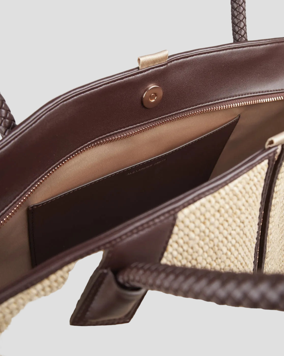 Interno borsa a spalla in rafia beige con dettagli e manico intrecciato marrone in pelle, chiusura zip