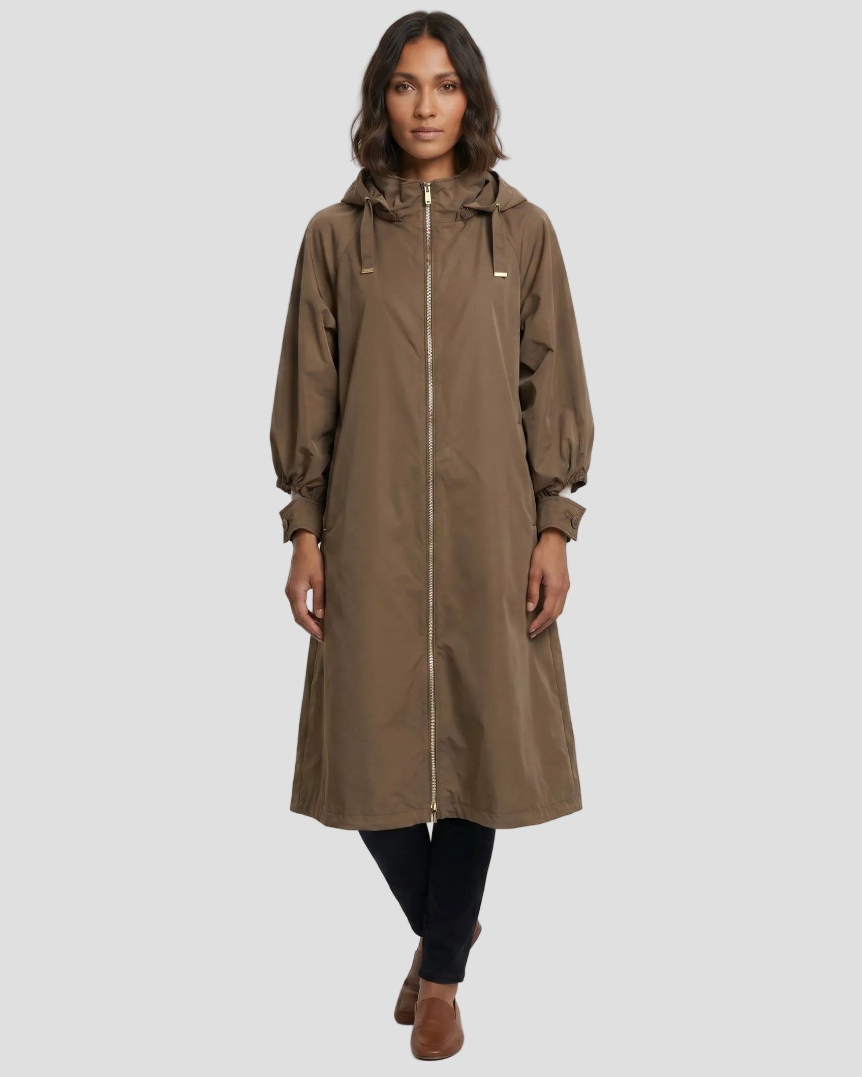 Parka DiegoM antigocca oversize color fango, modella di fronte che indossa pantaloni scuri e mocassini