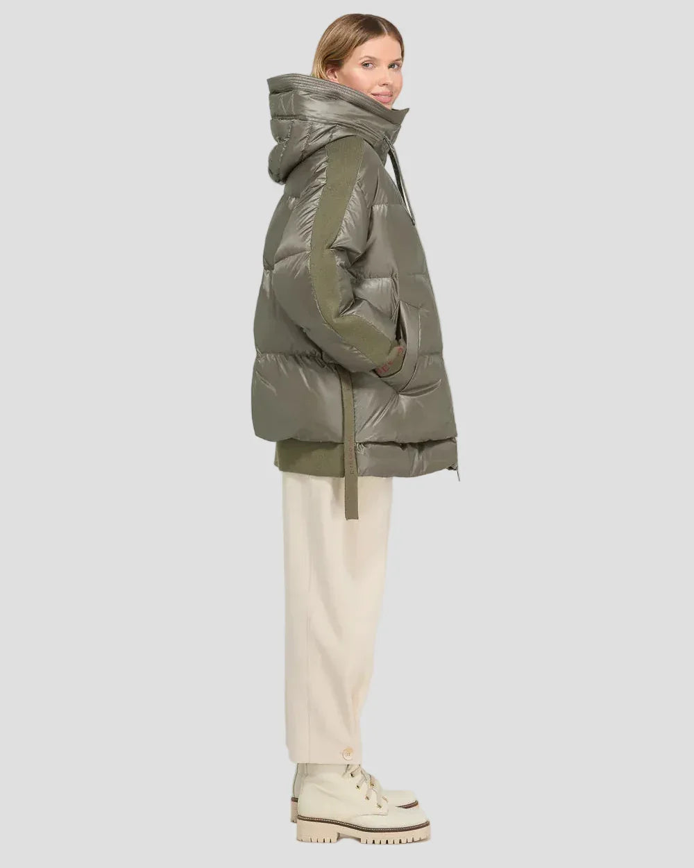 Piumino verde scuro donna con cappuccio, stile oversize, dettagli a contrasto e pantaloni chiari