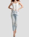 Top bianco donna in cotone con ricami pizzo frontali, canotta interna e
spalline a fiocco, modella indossa su un jeans chiaro e delle decollete