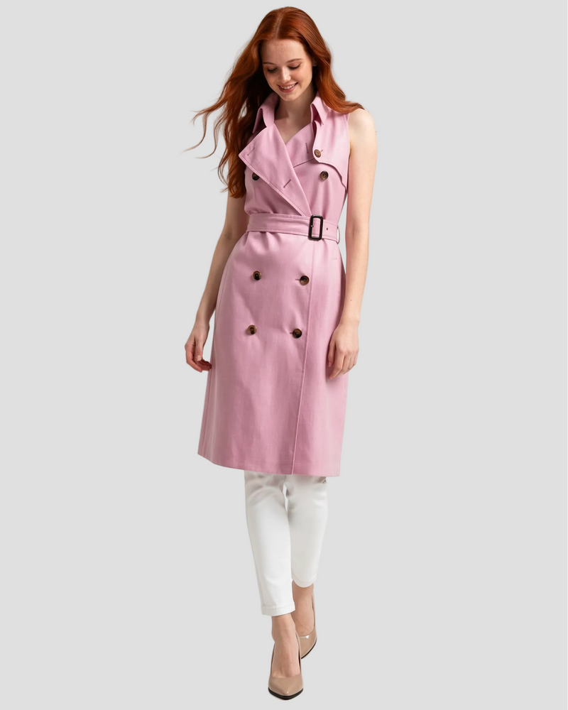 Modella in piedi che sorride mentre indossa un trench smanicato Graziani in seta e lino rosa